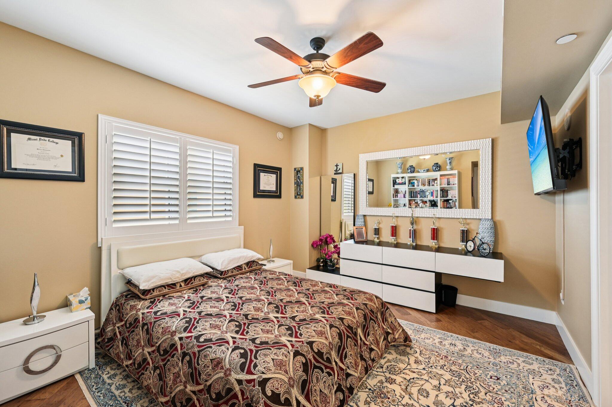 2640 Lake Shore Drive, Unit 1510 Riviera Beach, FL 33404 - Photo 25 of 52 a bedroom with a bed and a chandelier