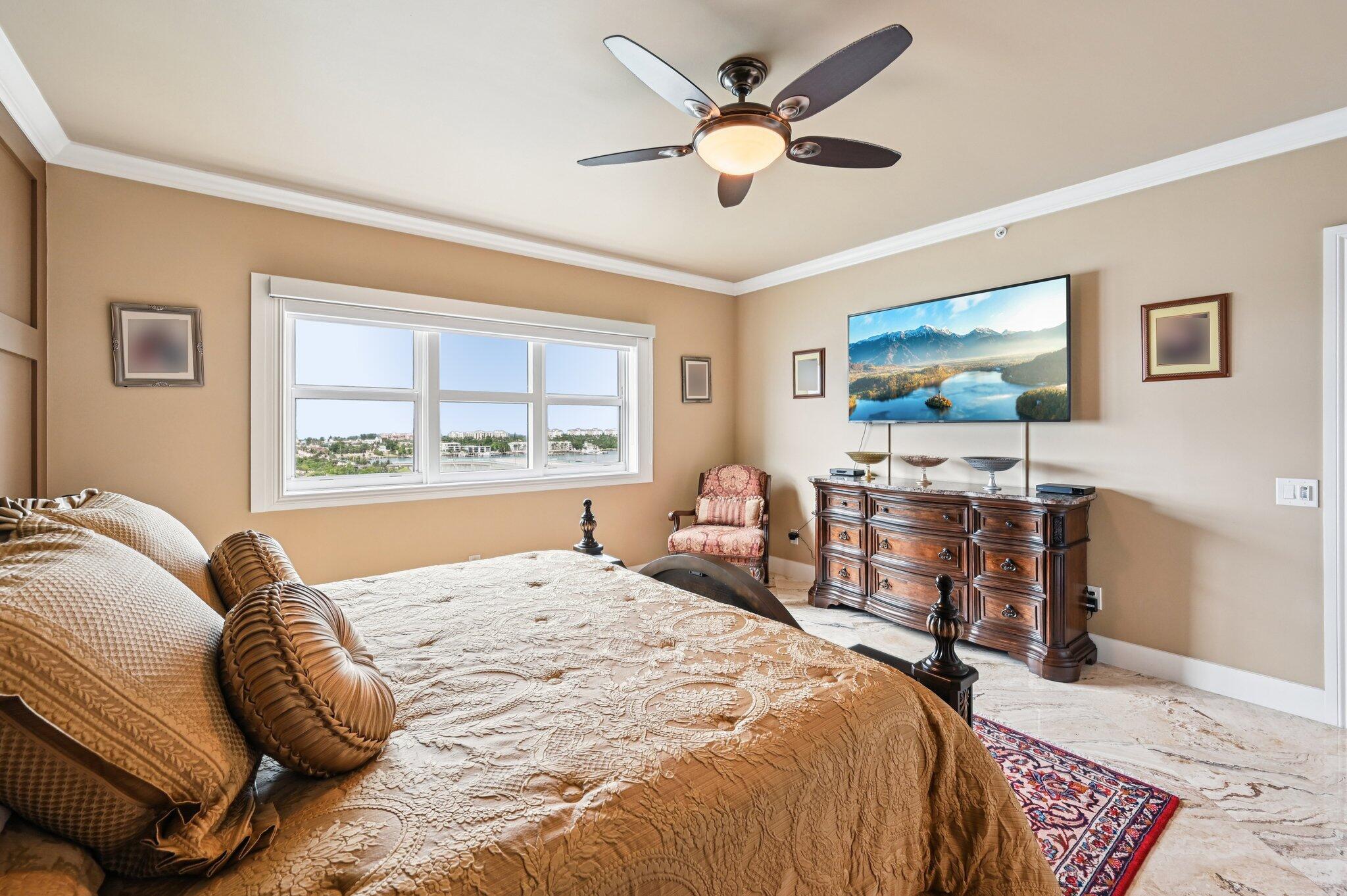 2640 Lake Shore Drive, Unit 1510 Riviera Beach, FL 33404 - Photo 30 of 52 a bedroom with a bed a table and a large window