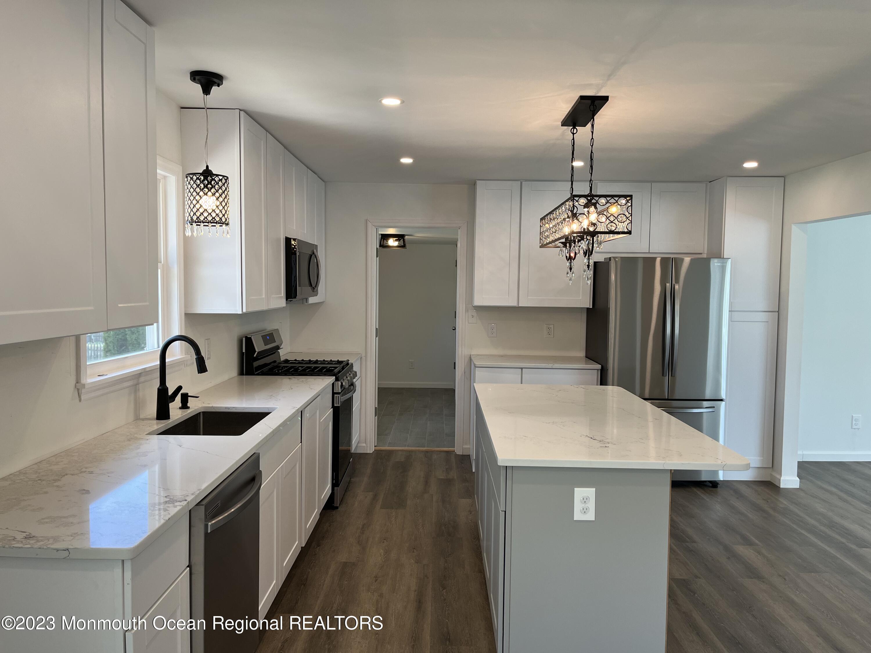 a kitchen with stainless steel appliances granite countertop a sink a stove and a refrigerator