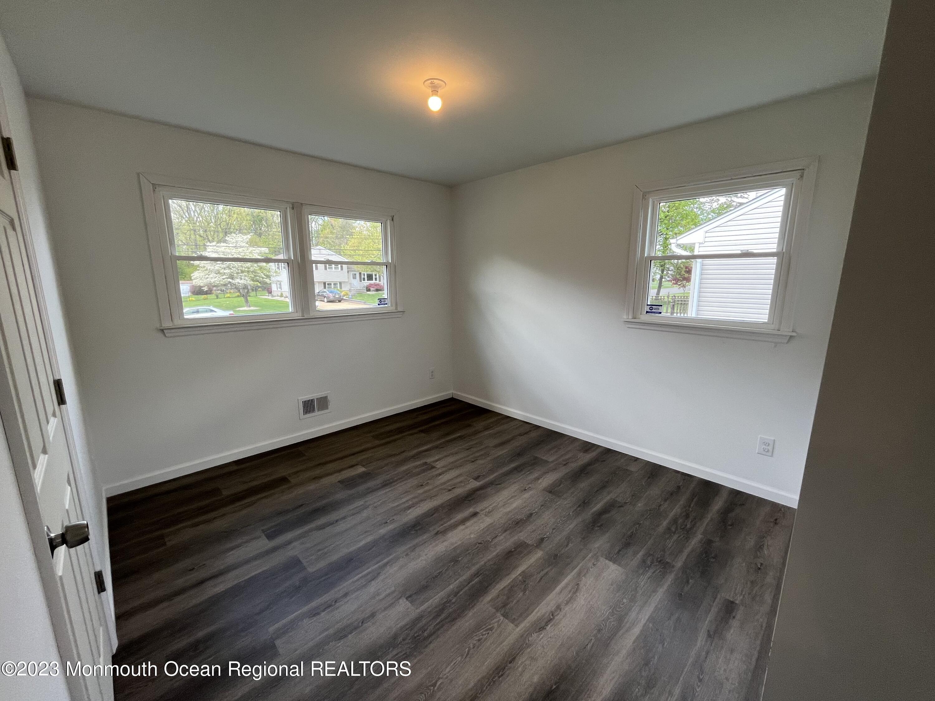21 Glenmore Road Freehold, NJ 07728 - Photo 12 of 14 an empty room with wooden floor and windows
