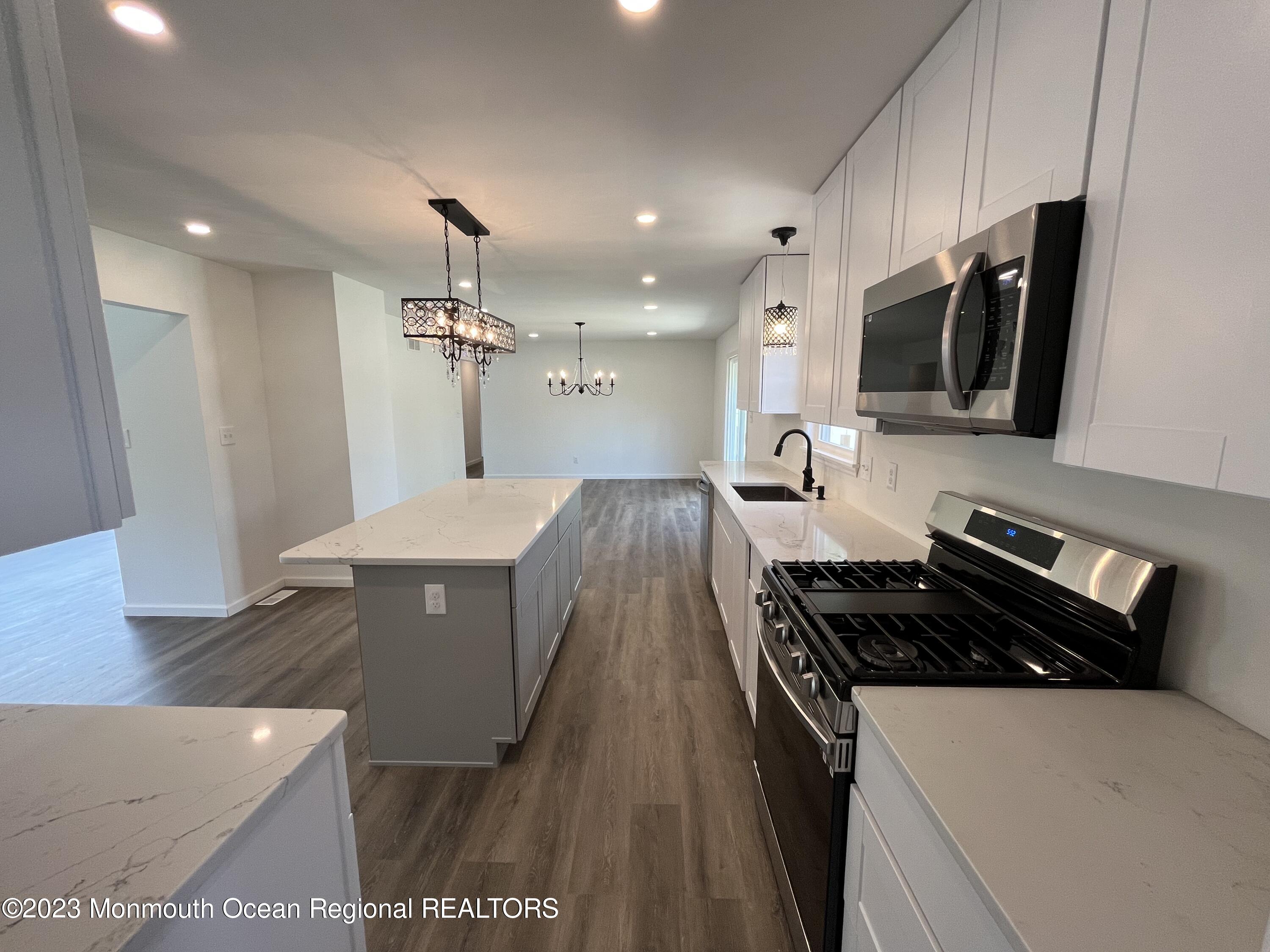 21 Glenmore Road Freehold, NJ 07728 - Photo 3 of 14 a kitchen with granite countertop a stove and a sink