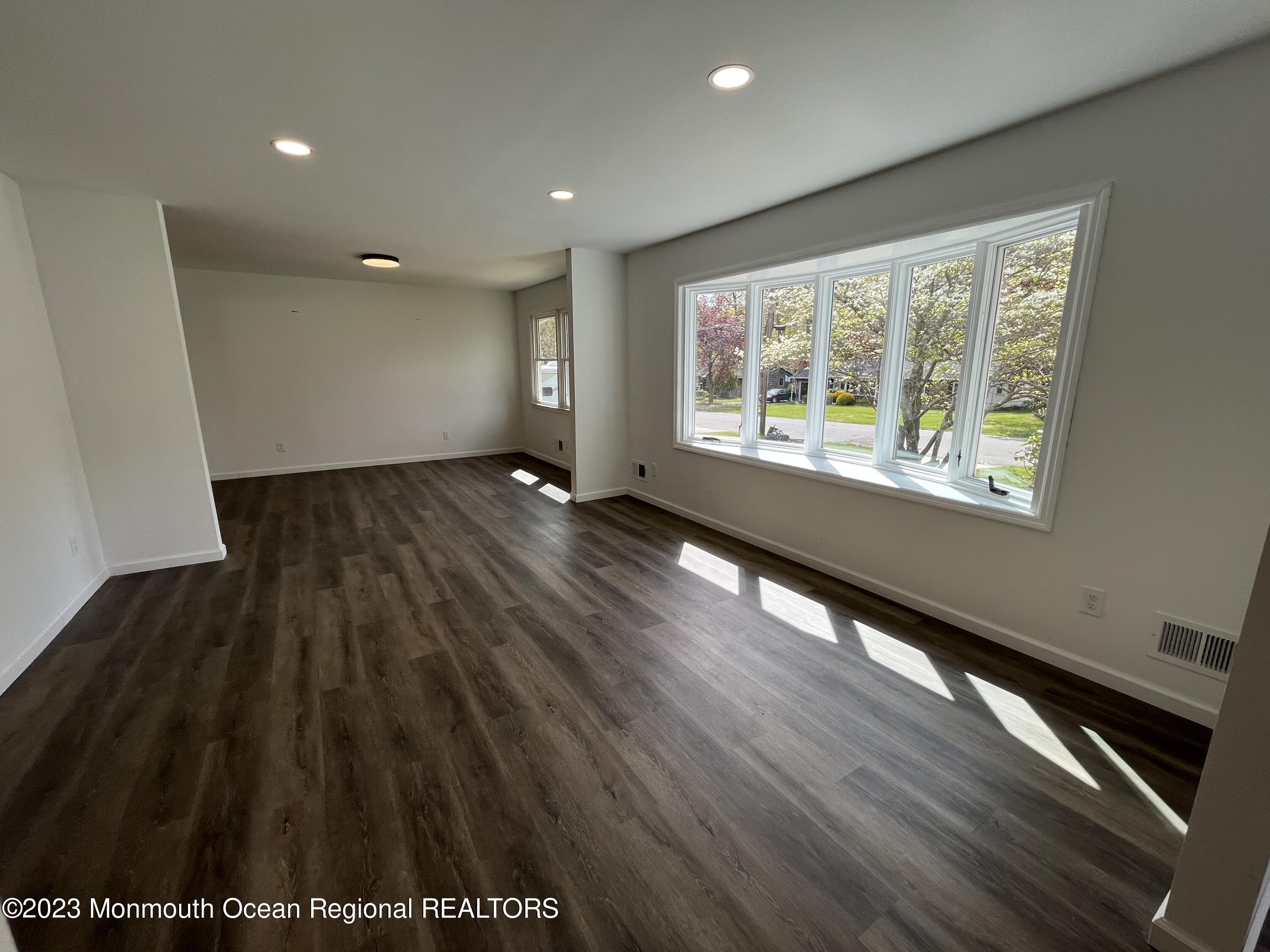 21 Glenmore Road Freehold, NJ 07728 - Photo 8 of 14 a view of an empty room with wooden floor and a window