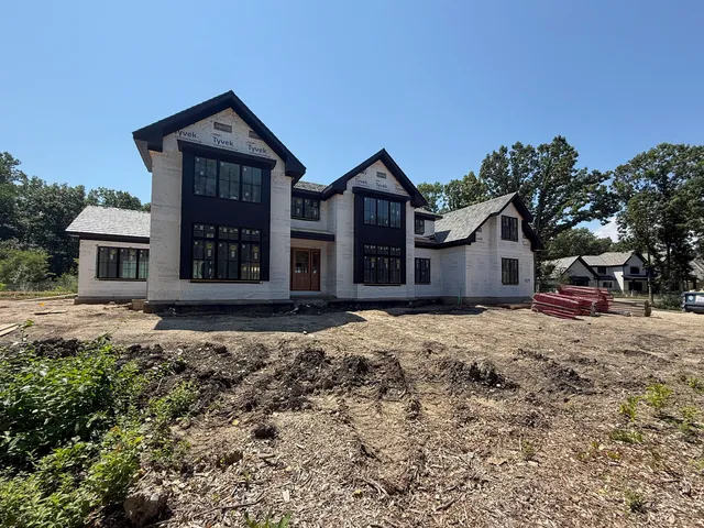 a living room with couches and kitchen view with wooden floor