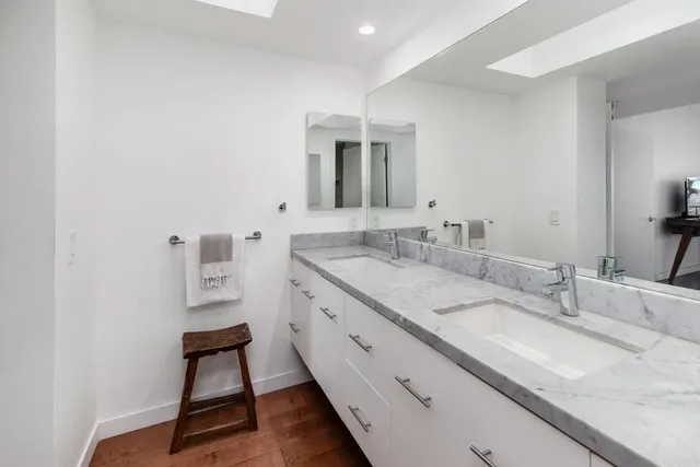 a bathroom with a granite countertop sink a toilet and a mirror