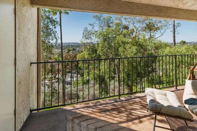a view of a balcony with chairs and wooden floor