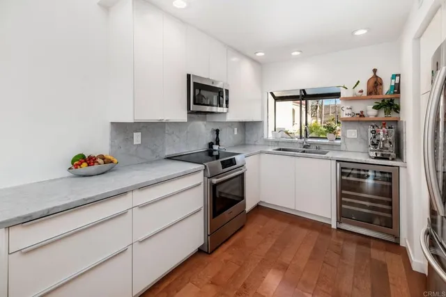 a kitchen with a sink window and stainless steel appliances