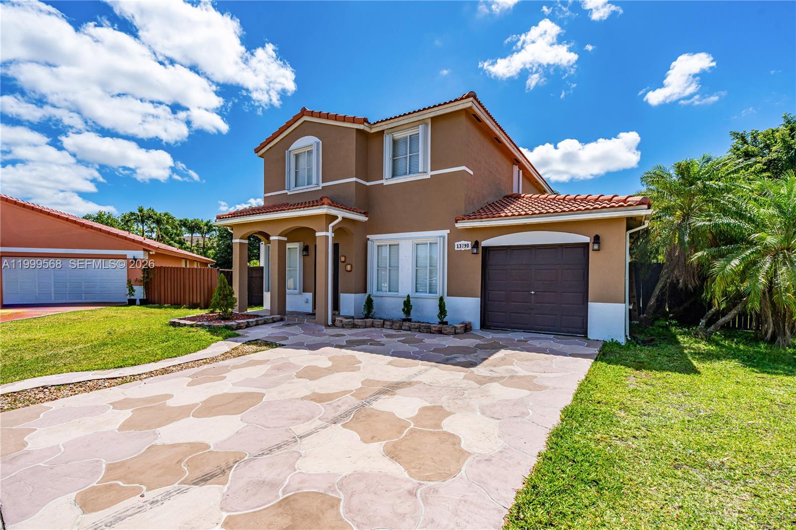 13790 Southwest 174th Street Miami, FL 33177 - Photo 2 of 41 a front view of a house with a yard and garage