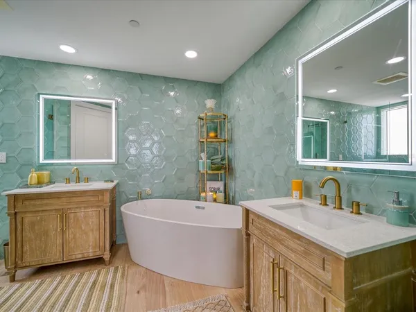 a bathroom with a bathtub a sink and a mirror