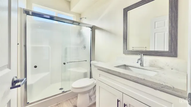 a bathroom with a granite countertop sink toilet and shower