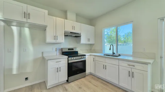 a kitchen with white cabinets and white appliances