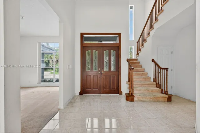 a view of an empty room with window and fireplace