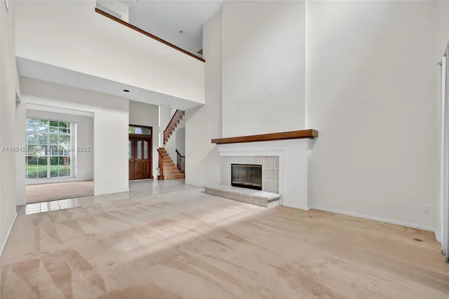 a view of an empty room with a fireplace and a window