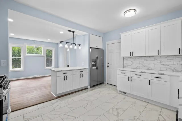 a kitchen with granite countertop a refrigerator stove and sink