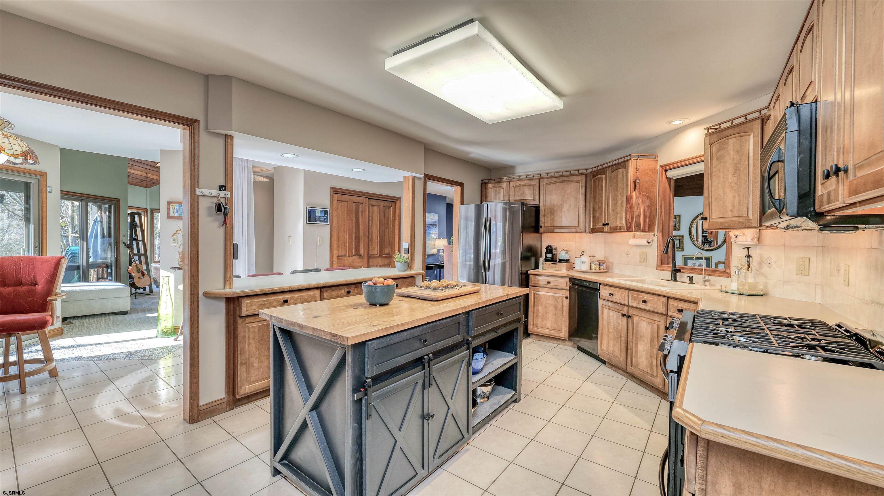 3 School House Road Egg Harbor Township, NJ 08234 - Photo 13 of 56 a kitchen with stainless steel appliances granite countertop a stove top oven a sink a dining table and chairs with white cabinets
