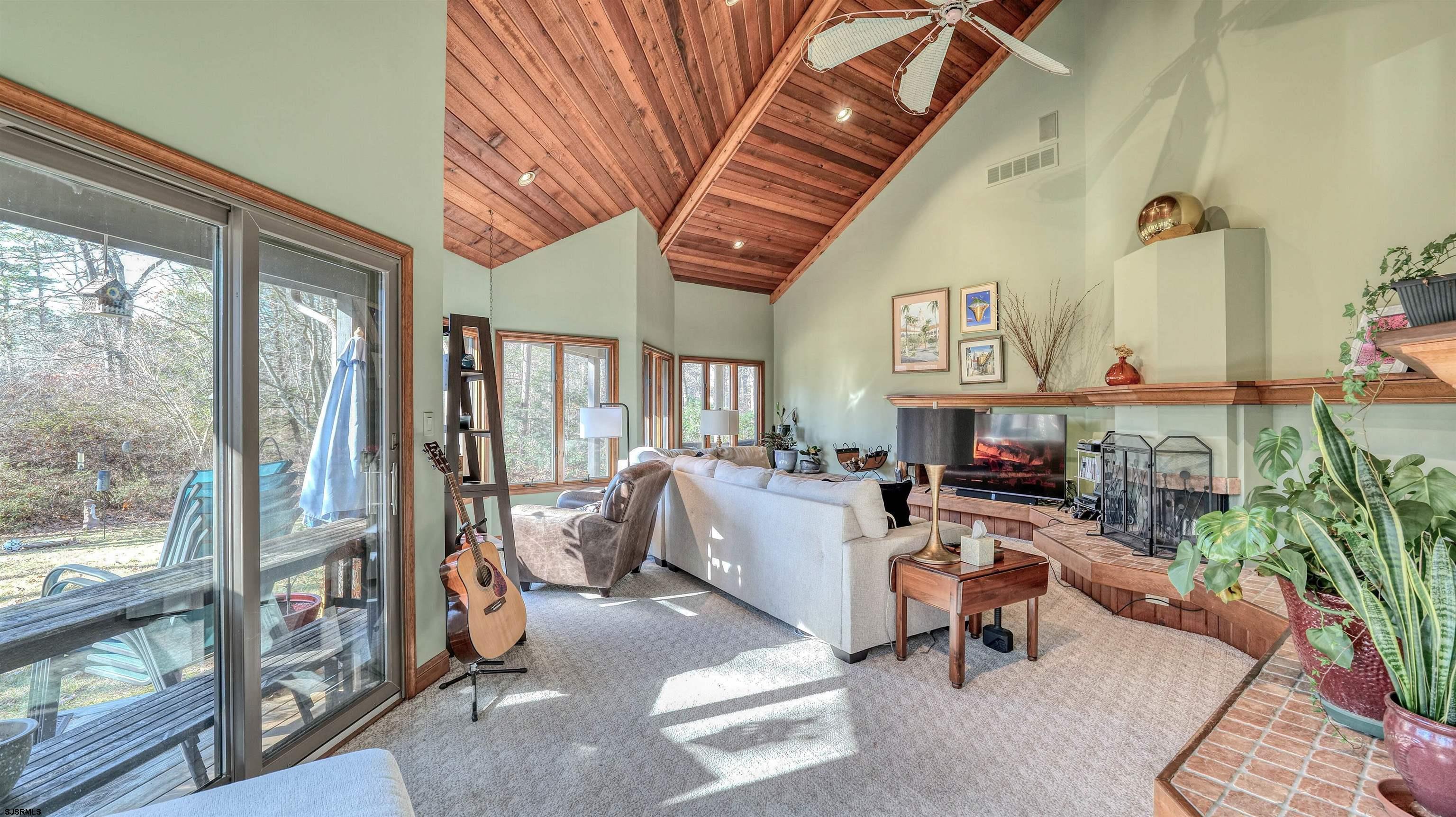 3 School House Road Egg Harbor Township, NJ 08234 - Photo 17 of 56 a living room with furniture a fireplace and a floor to ceiling window