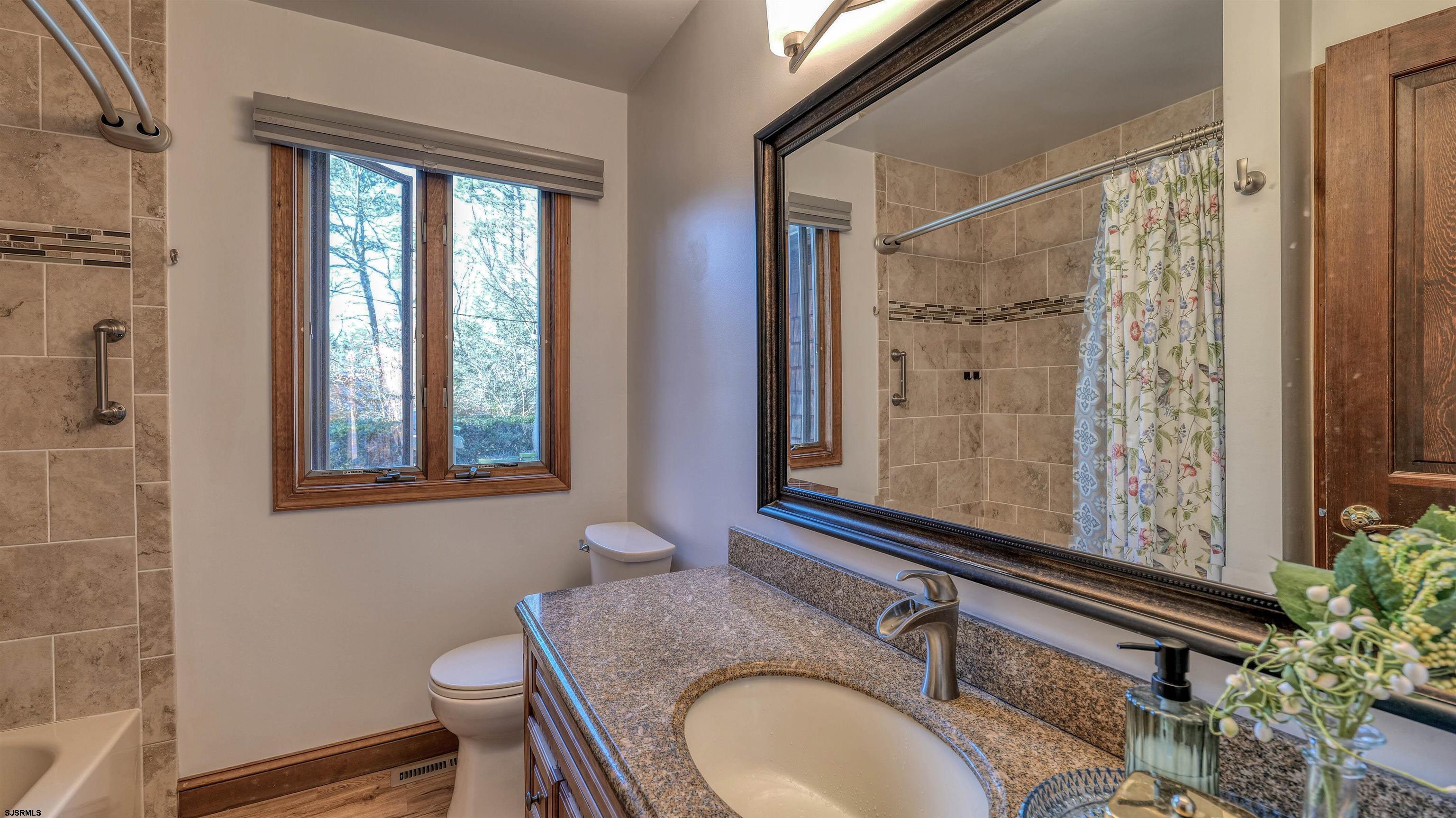 3 School House Road Egg Harbor Township, NJ 08234 - Photo 20 of 56 a bathroom with a granite countertop sink toilet a mirror and shower