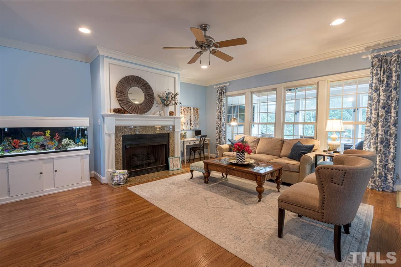 2916 SnapsWell Street Raleigh, NC 27614 - Photo 9 of 30 Inviting Family Room Complete with Hardwoods, Gas Fireplace, Wall of Windows looking into Three Season Room and Open to the Kitchen. Great for Entertaining !