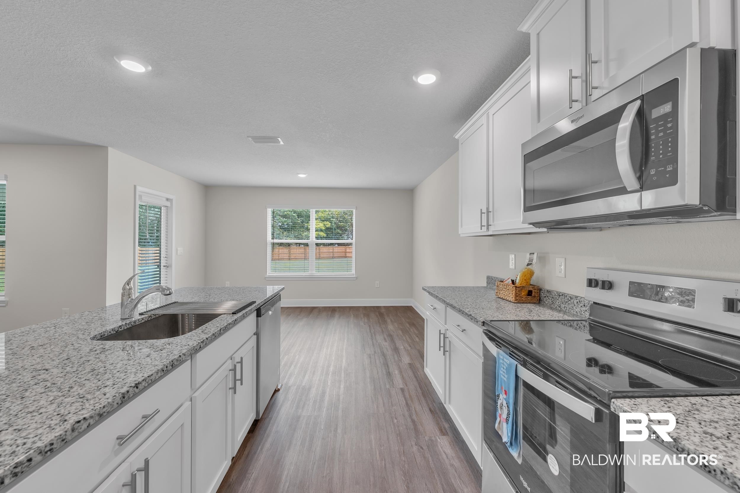 24460 Ringneck Loop Elberta, AL 36530 - Photo 23 of 46 Kitchen featuring white cabinetry, a sink, visible vents, stainless steel appliances, and dark wood-style floors