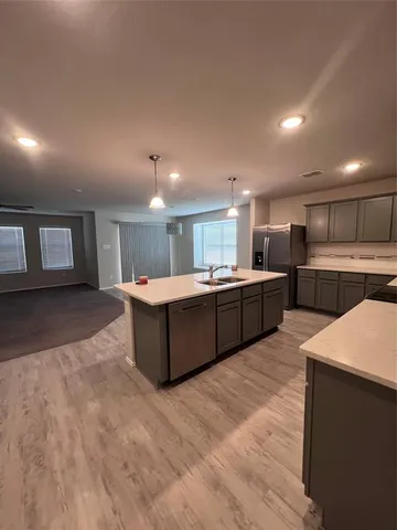 a large white kitchen with a sink a microwave and cabinets