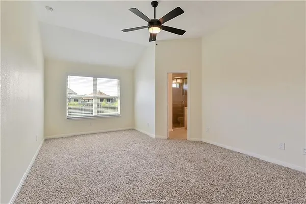 an empty room with fan and windows