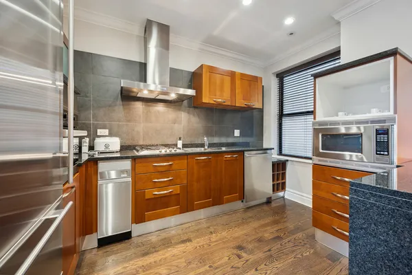 a kitchen with stainless steel appliances granite countertop a stove a sink and a microwave