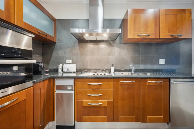 a kitchen with stainless steel appliances granite countertop wooden cabinets and a counter top space