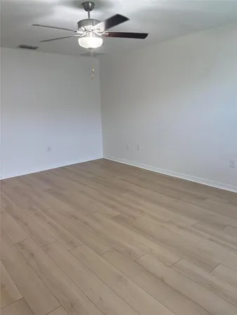 a view of a chandelier fan and hardwood floor