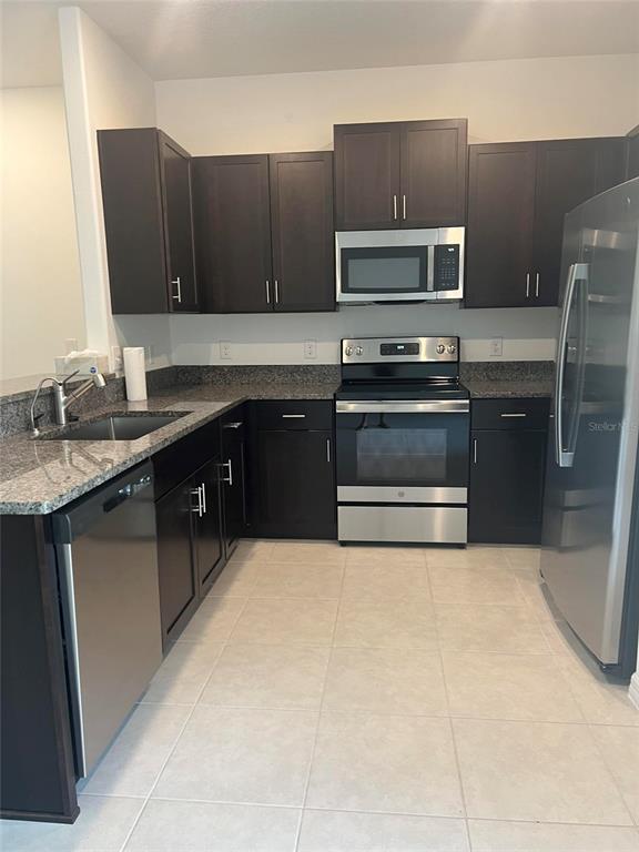 14442 Editors Note Street Ruskin, FL 33573 - Photo 2 of 31 a kitchen with a sink stove and microwave