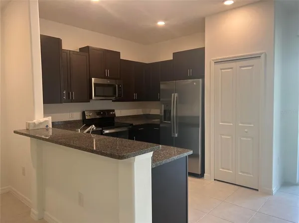 a kitchen with stainless steel appliances granite countertop a refrigerator and a sink
