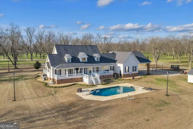 a view of a house with swimming pool and a yard