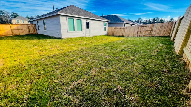 a view of a backyard with plants and wooden fence