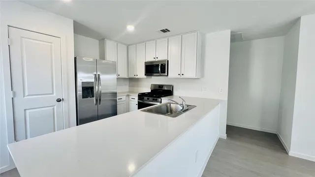 a kitchen with cabinets and stainless steel appliances