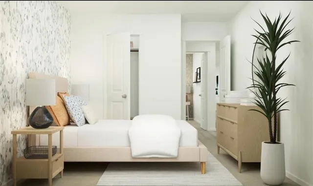 a bedroom with a bed and a potted plant