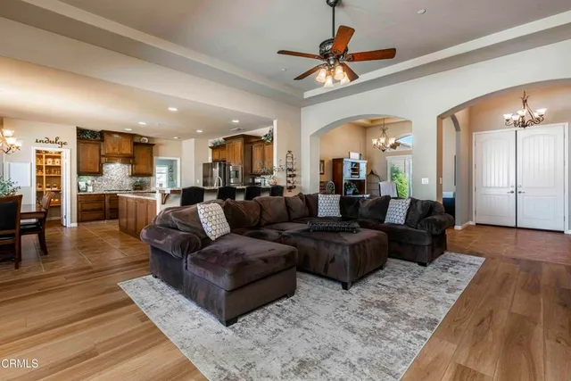 a kitchen with stainless steel appliances granite countertop a refrigerator a sink dishwasher a oven with white cabinets and wooden floor