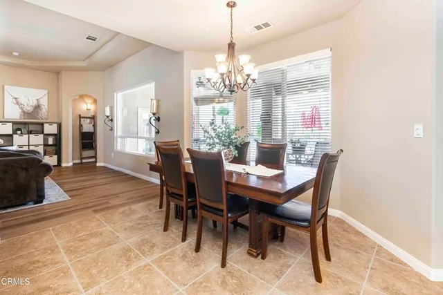 a kitchen with stainless steel appliances kitchen island granite countertop a refrigerator a sink a stove a dining table and chairs