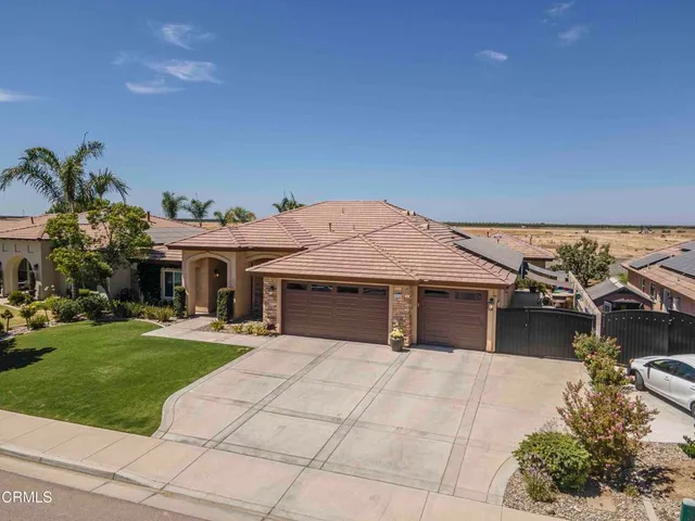 an aerial view of a house with garden space and street view
