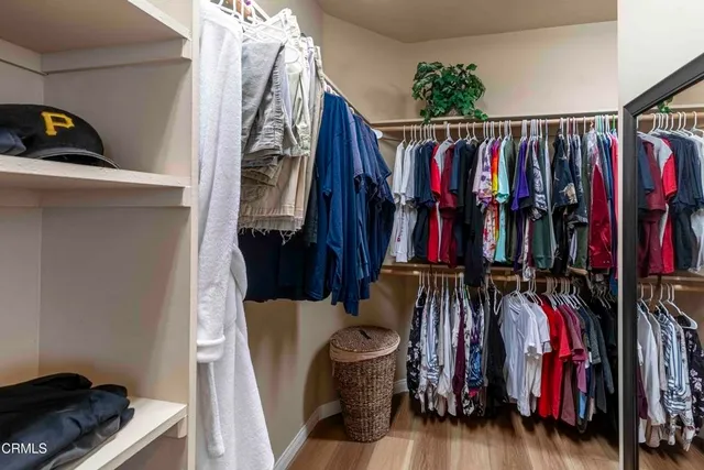 a view of walk in closet with clothes and shoes