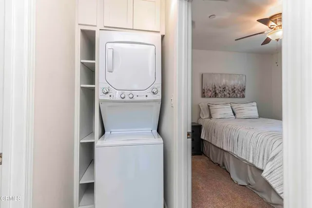 a view of a backyard with chairs and potted plants