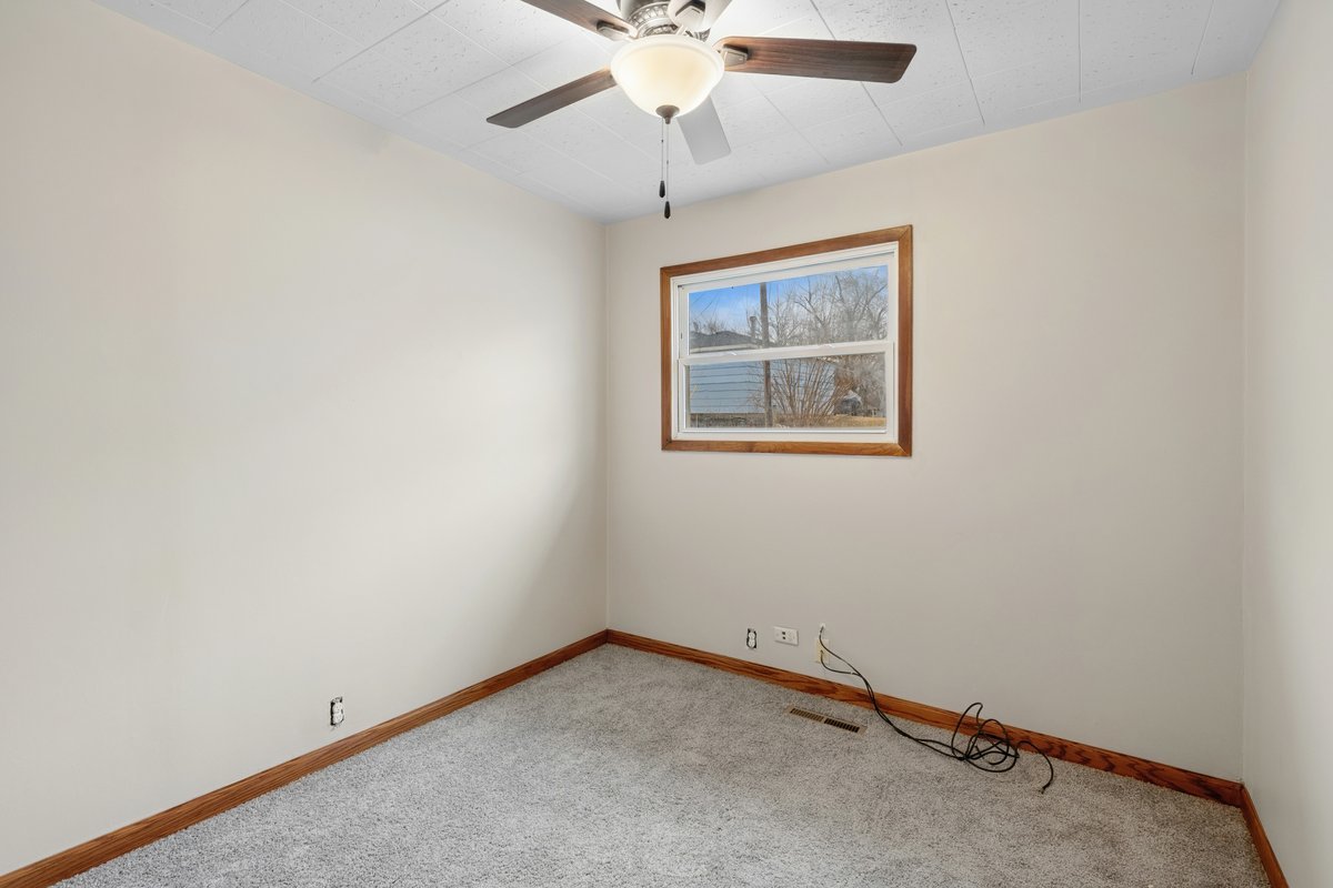 59 Wren Road Carpentersville, IL 60110 - Photo 12 of 19 an empty room with a ceiling fan and a window