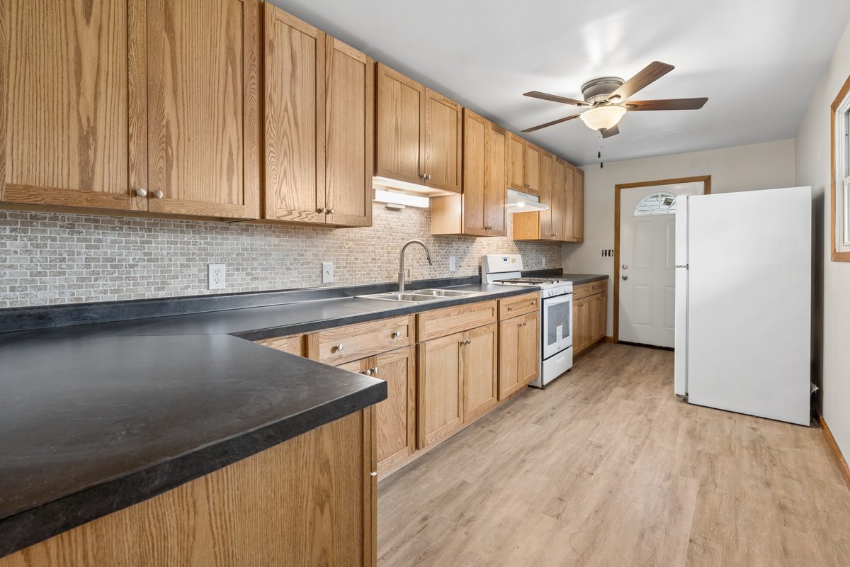 59 Wren Road Carpentersville, IL 60110 - Photo 7 of 19 a kitchen with a sink a refrigerator and cabinets