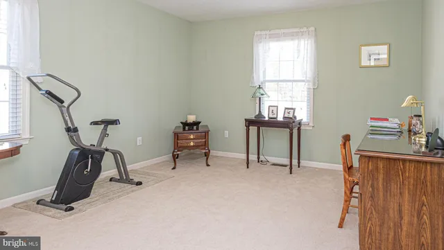 a view of a workspace with furniture and a window