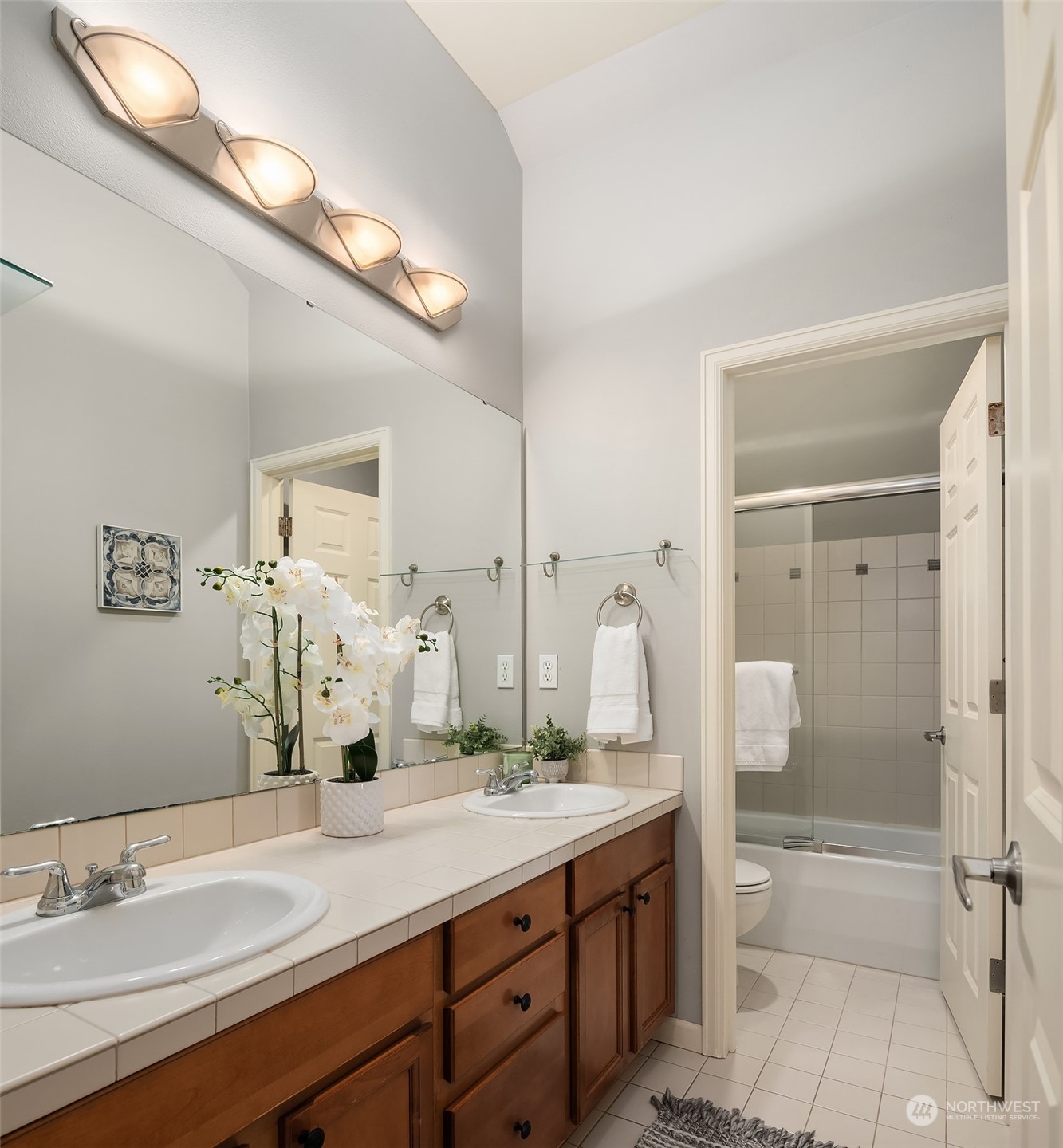 8517 Interlake Avenue North, Unit A Seattle, WA 98103 - Photo 16 of 20 a bathroom with a granite countertop sink a mirror and a shower