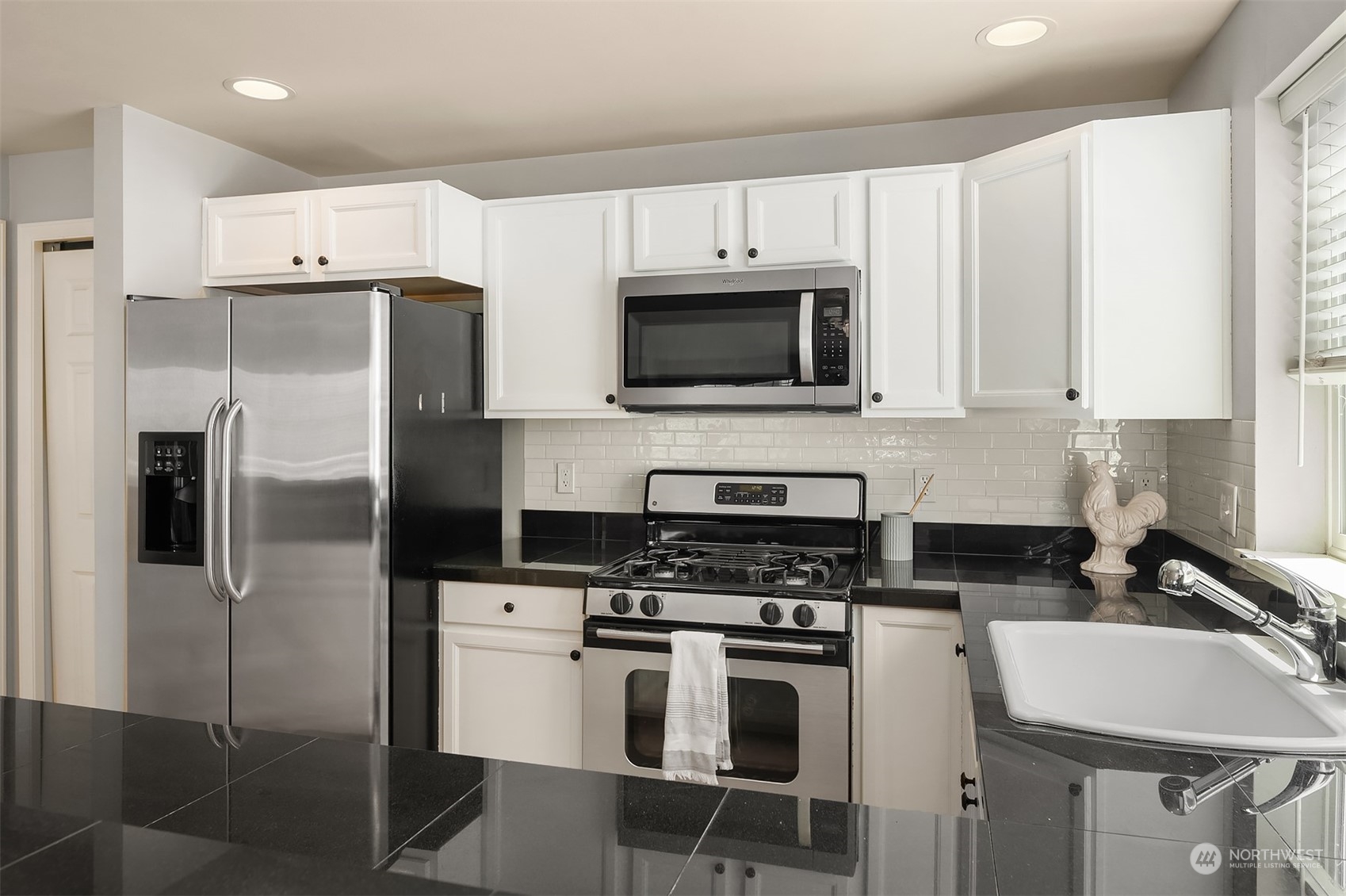 8517 Interlake Avenue North, Unit A Seattle, WA 98103 - Photo 8 of 20 a kitchen with stainless steel appliances a refrigerator stove and microwave