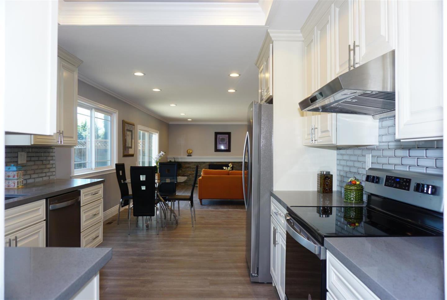 Kings Place Gilroy, CA 95020 - Photo 23 of 37 a kitchen with stainless steel appliances granite countertop a stove top oven a sink dishwasher and a dining table with wooden floor