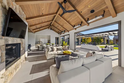 a living room with patio furniture and a flat screen tv