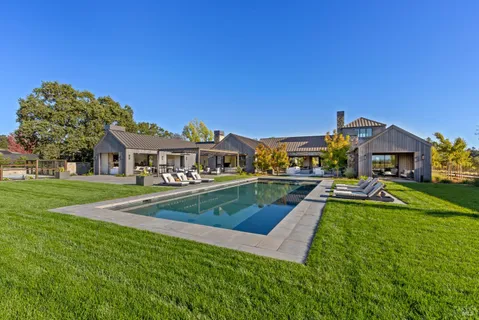 an aerial view of residential houses with outdoor space and river