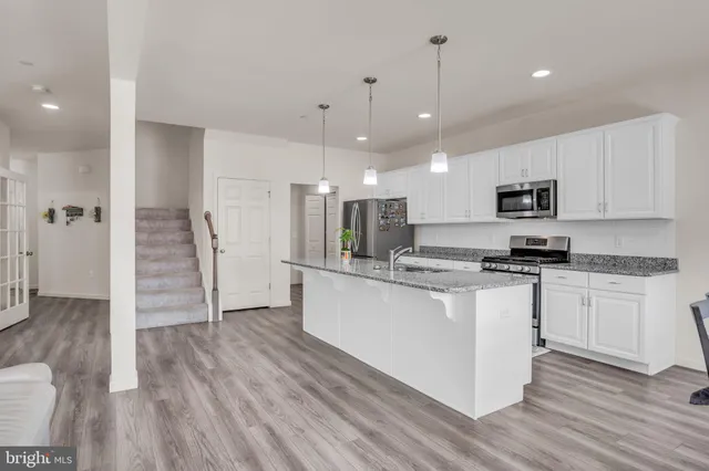 a kitchen with stainless steel appliances granite countertop a stove a sink and a refrigerator