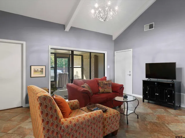 a living room with furniture a flat screen tv and a large window