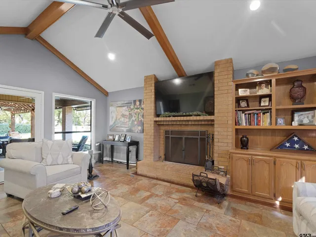 a living room with furniture a fireplace and a flat screen tv