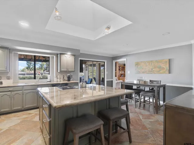 a dining hall with stainless steel appliances granite countertop a dining table and chairs